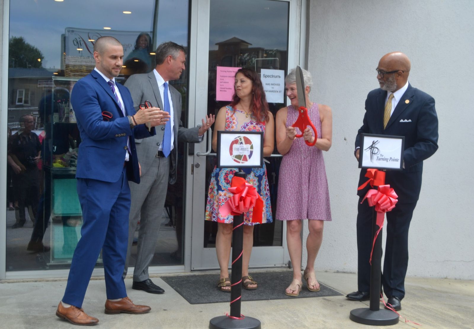 Ryan Coleman (left), director of the city of Columbia's Office of Economic Development, joins Columbia Mayor Daniel Rickenmann (second from left) and City Councilman Ed McDowell (right) in helping Coleen Strasburger (with scissors) cut the ribbon on The Turning Pointe's new location. (Photo/Melinda Waldrop)