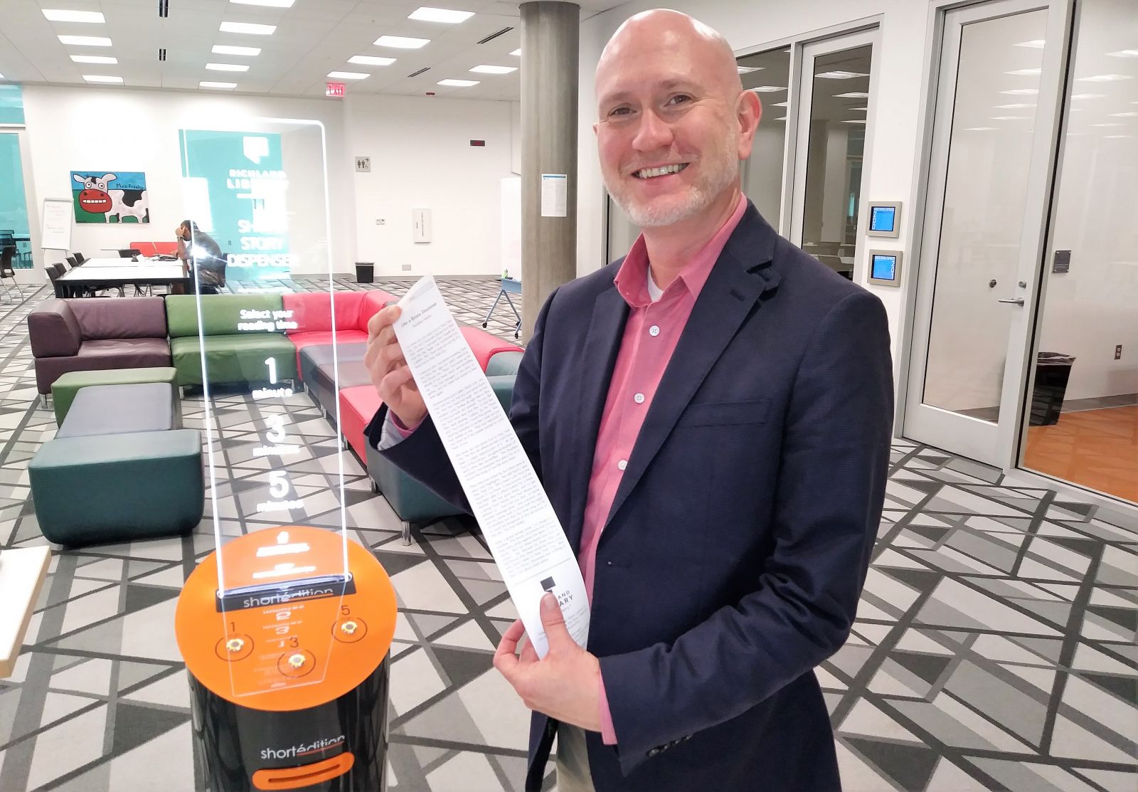 Tony Tallent, chief program and innovation officer at Richland Library, with the spoils from a short story dispenser.  (Photo/Travis Boland)