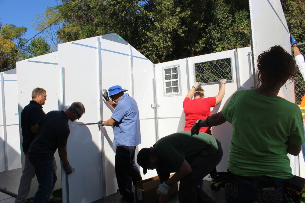 Workers put together one of 54 Pallet sleeping cabins which will soon house clients at the new Rapid Shelter Columbia, set to open Nov. 1. (Photo/Christina Lee Knauss)