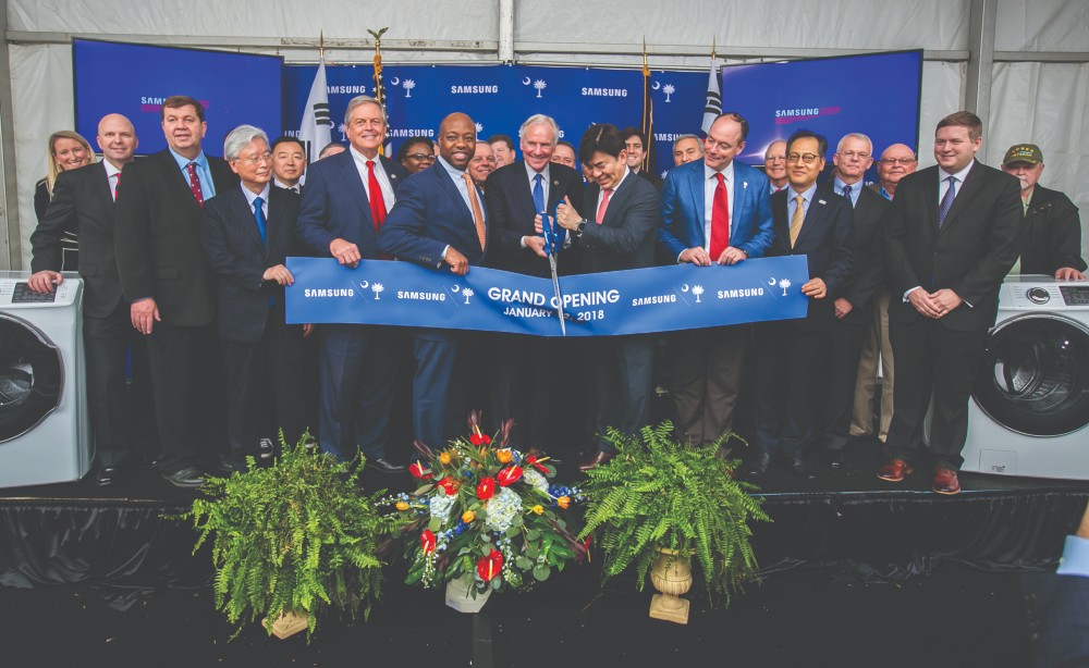 Officials, including S.C. Gov. Henry McMaster (with scissors) and Sen. Tim Scott (to McMaster's right) celebrate Samsung's grand opening of its Newberry plant in 2018. (Photo/File)