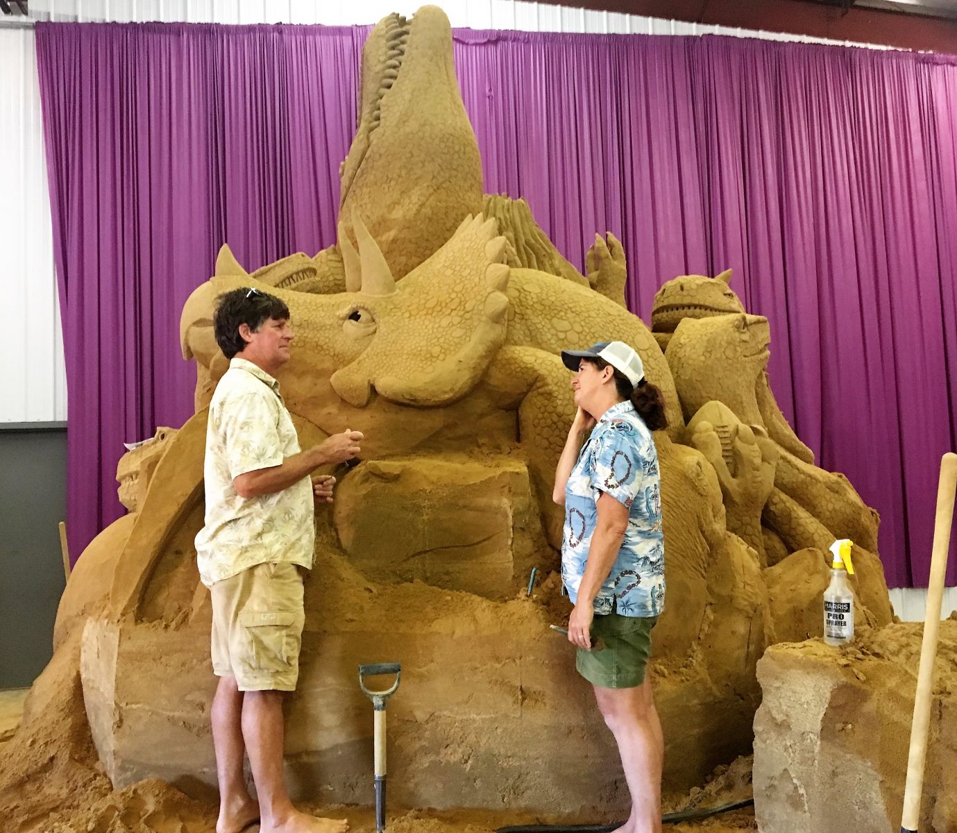 Husband-and-wife sand sculpting duo Greg and Brandi Glenn work on a dinsoaur-themed sculpture at the S.C. State Fair. (Photo/Melinda Waldrop)