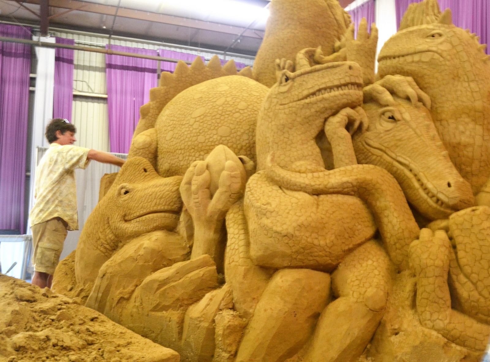 Greg Glenn works on the dinsosaur sand sculpture he and wife and business partner Brandi Glenn carved at the S.C. State Fair. (Photo/Melinda Waldrop)
