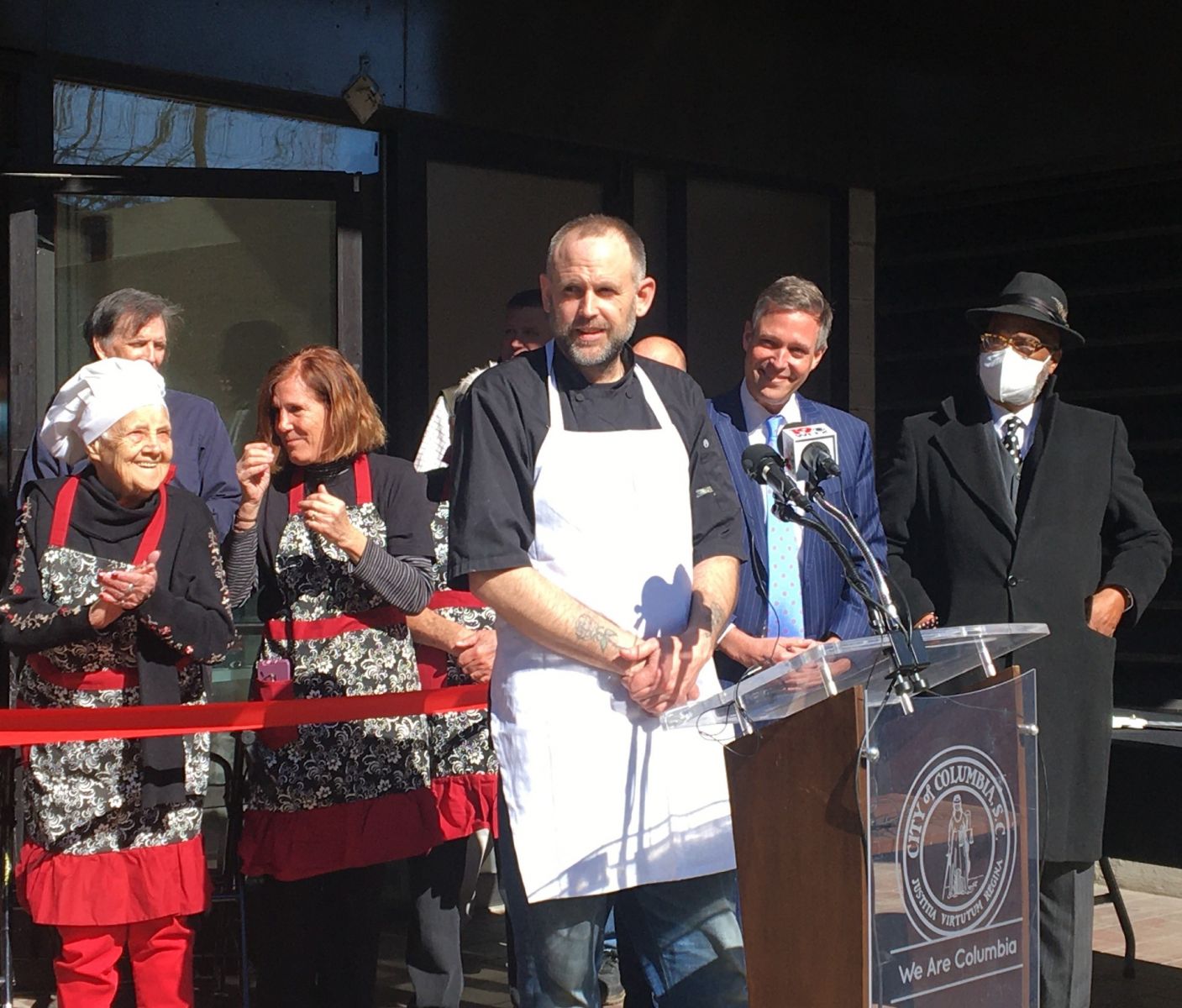 The Strudel Shop chef and owner Kevin Kelly addresses the crowd at Thursday's ribbon cutting, flanked by (from right) Columbia Mayor Daniel Rickenmann and Columbia City Counciilman Edward McDowell. Far left is Kelly's grandmother, Virginia Johnson. 