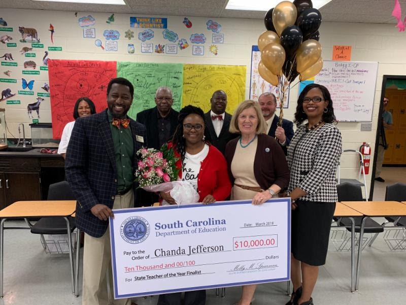 Fairfield Central biology teacher Chanda Jefferson (with roses) learns from S.C. Superintendent of Education Molly Spearman (to her right) that she is one of five finalists for the 2019 S.C. Teacher of the Year award. (Photo/Provided)